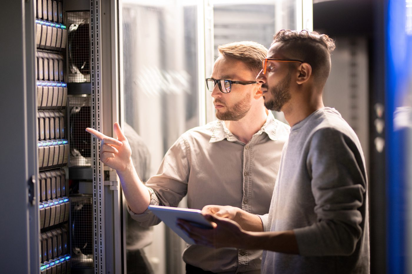 A pair of data center employees examine a server.